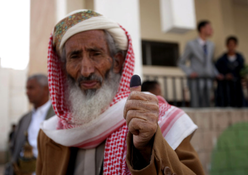 A Yemeni man shows his ink-stained thumb
