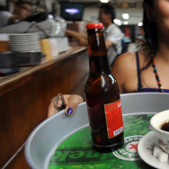 A waitress takes a coffe and a beer to a