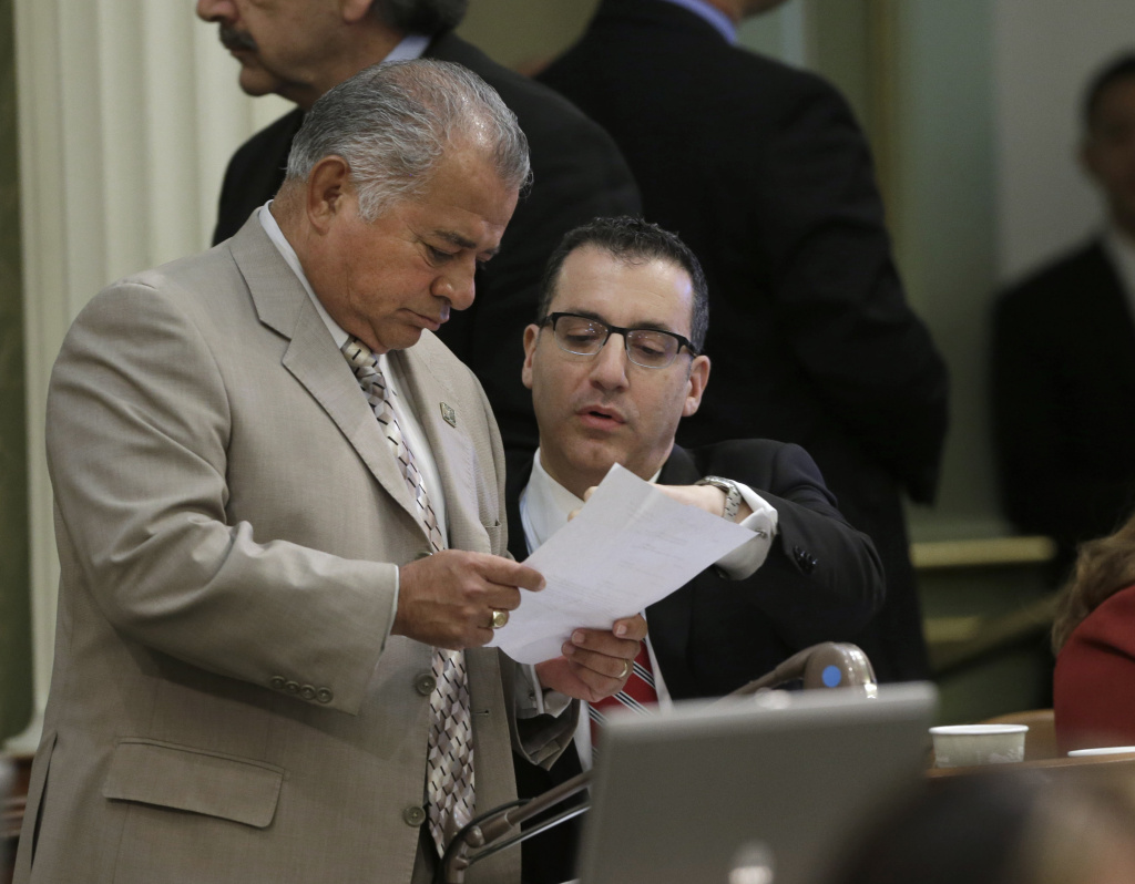 In this file photo, Assemblyman Rocky Chavez, R-Oceanside, left, talks with Assemblyman Bob Blumenfield, R-Woodland Hills, chairman of the Assembly budget committee, as the Assembly worked on the state budget at the Capitol, Friday, June 14, 2013 in Sacramento, Calif. Chavez had been running to replace outgoing U.S. Senator Barbara Boxer, but on Monday he abruptly announced he was dropping out.