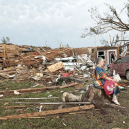 Barbara Garcia, right, sits with friends after a tornado destroyed much of their neighborhood in Moore, Okla. During an interview with CBS, Garcia found her dog buried in the wreckage of her house.