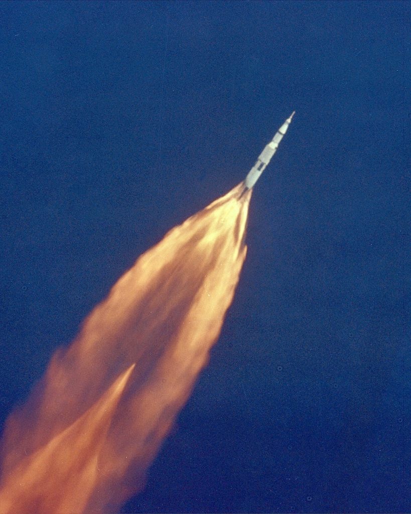 Apollo 11 climbs toward orbit after liftoff on July 16, 1969. In 2 1/2 minutes of powered flight, the S-IC booster lifts the vehicle to an altitude of about 39 miles, some 55 miles downrange.