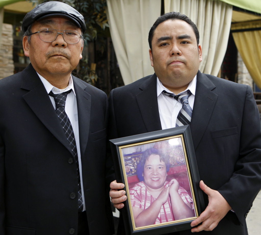 This Thursday, Feb. 4, 2010 file photo shows Jeffrey Uno, right, and his father, Peter Uno, the son and husband of Noriko Uno, in framed photo, who died in an alleged "sudden unintended acceleration" crash in a Toyota Camry in August 2009, in Los Angeles. A jury on Thursday Oct. 10, 2013 found Toyota not liable for death of Noriko Uno.