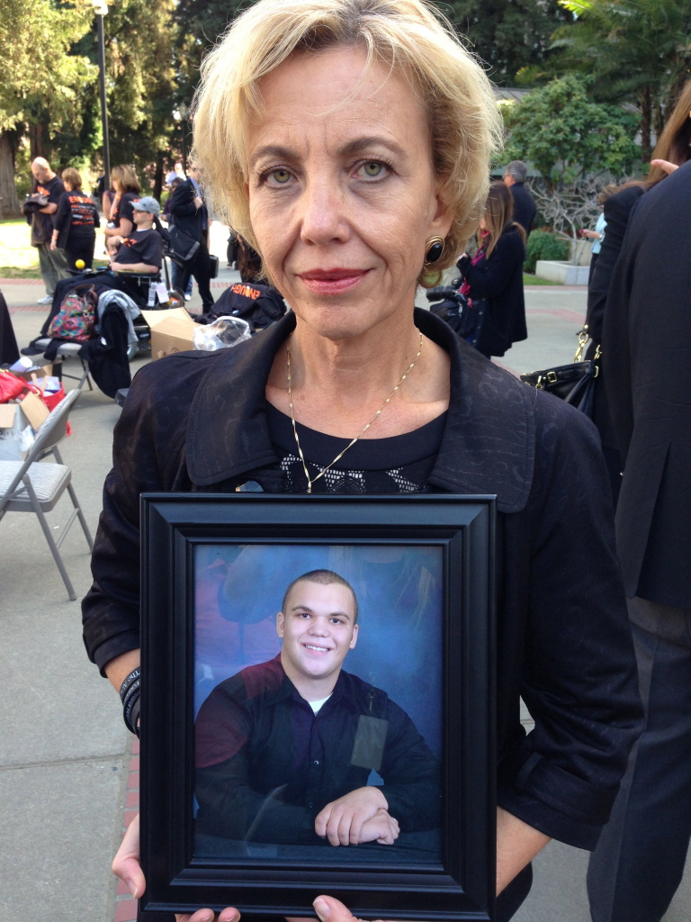 Tammy Smick holds a photograph of her son, Alexander, who died February 23, 2012 of an overdose. Smick told lawmakers the doctor who prescribed the lethal drugs practices medicine in Long Beach.