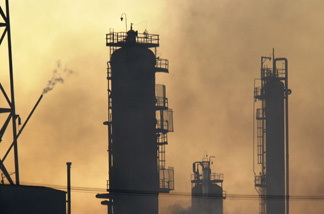 Smoke rises around towers at a Tosco oil refinery at sunset after a fire burning as hot as 2,000 degrees Farenheit melted steel and sent a huge cloud of toxic smoke across the urban landscape, April 23, 2001 in Carson, CA, 15 miles south of Los Angeles.