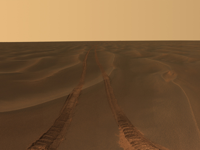 Tracks from NASA's Opportunity rover disappear toward the horizon on the Meridiani Plains of Mars. The rover has been on the planet since 2004.