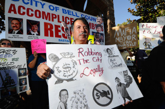 Mario Sanchez, a resident of the City of Bell, holds a protest placard calling for the ouster of city officials before the start of a council meeting on July 26, 2010 in Bell, California.