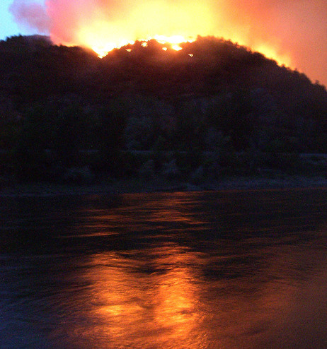 June 8: Flames from the Hayman wildfire, burning in in the Rocky Mountains southwest of Denver, reflect on the Colorado River.