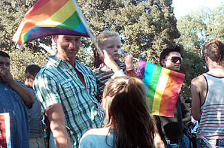 Mark Hiebert holds his 4-year-old son, Logan, while his 6-year-old daughter Amira waves a rainbow flag at West Hollywood Park.