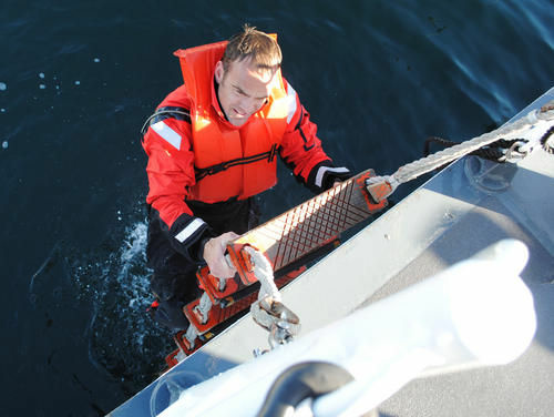 Coast Guard Chief Petty Officer Terrell Horne, stationed on the Cutter Halibut, climbs up onto the ship after conducting water survival training in this undated photograph. Chief Horne, a Boatswain Mate, was killed in the early morning of Dec. 2, 2012, from injuries sustained during law enforcement operations near Santa Cruz Island, Calif. The Coast Guard Cutter Halibut was investigating a panga-type vessel suspected of illicit activities. When the Halibut's small boat approached with its blue law enforcement light energized, the suspect vessel, identified to be a profile Mexican style panga, maneuvered at a high rate of speed directly towards the Coast Guard small boat and struck it before fleeing the scene.