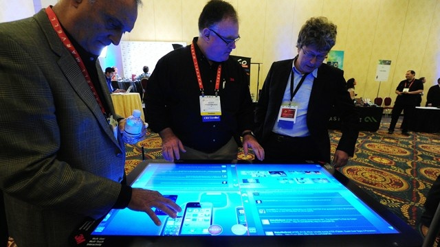People sample a 3M Touch Systems 46-inch PCT-display demonstrating the scalability of projective capacitive technology at CES Unveiled, ahead of the opening of the annual Consumer Electronics Show, Jan. 8, 2012 in Las Vegas, Nevada.