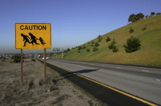 An old highway sign near the U.S.-Mexico border with an image of a migrant family. In recent years, the number of underage migrants traveling without a parent has increased: Last year, the U.S. Border Patrol took in three times the number of unaccompanied minors that it did in 2008, according to government statistics.