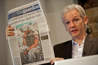 Australian founder of whistleblowing website, 'WikiLeaks', Julian Assange holds up a copy of The Guardian newspaper during a press conference in London on July 26, 2010.