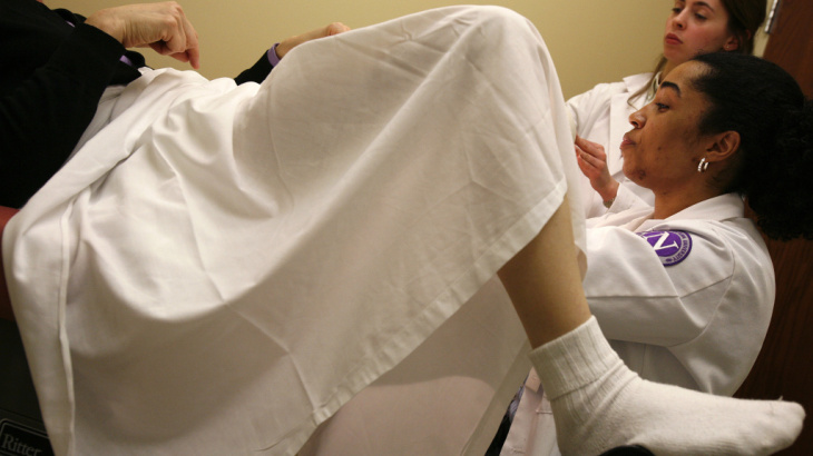 First-year medical student Michelle Gentile assists her classmate Abbie Harts as she performs a pelvic exam on a volunteer at Northwestern University.
