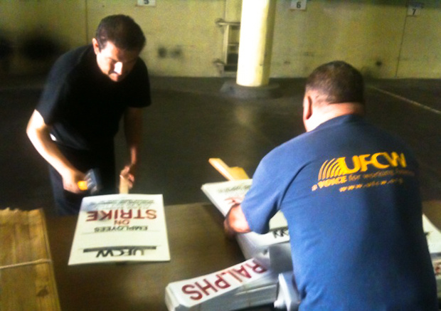 UFCW employees Jose Cruz (left) and Armando Espinoza prepare picket signs.