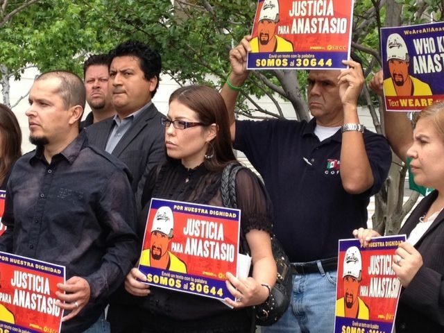Family members and activists, including Jose Gutierrez (far left), protest outside a federal building downtown supporting the "Todos Somos Anastasio" campaign.