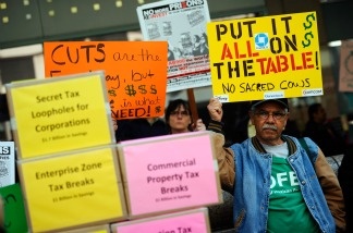 Angel Sequeira holds a sign during a rally against the proposed California budget cuts in front of Gov. Jerry Brown's office on Jan. 10, 2011 in Los Angeles. Several union and community activist groups representing the disabled attended the rally.