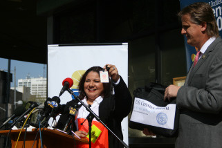 U.S. Census official Maria Claudio shows the badge and vest that will be worn by census workers, while James Christy, Los Angeles regional director of the U.S. Census Bureau looks on.