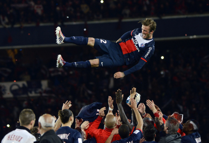 Paris Saint-Germain's English midfielder David Beckham is thrown in the air by teammates after a French L1 football match between Paris St Germain and Brest on Saturday at Parc des Princes stadium in Paris.