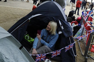 People sit on the Mall as they reserve their space prior to the Royal Wedding tomorrow.