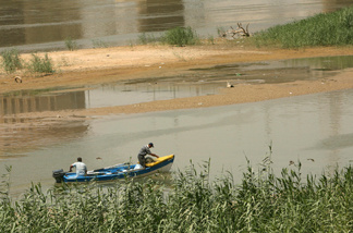 Iraqi fishermen ride their motor boat in the waters of the Tigris River in Baghdad on August, 13 2009. Iraq's water minister accused Turkey on August 11 of breaking a promise to increase water flows down the Euphrates river, saying Ankara was actually holding back on the precious commodity.