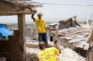 Joseph Gereso, with sledgehammer, and Jacky Jills loosen rubble in a destroyed house in the Fort National neighborhood on July 12, 2010 in Port-au-Prince, Haiti.
