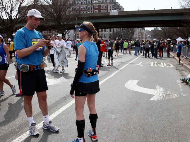 A runner using his cell phone after two bombs exploded at the Boston Marathon on Monday.