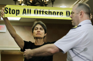 An unidentified protester is removed from the room after holding up a sign during a hearing by the Coast Guard and the Interior Department's Minerals Management Service on May 11, 2010.
