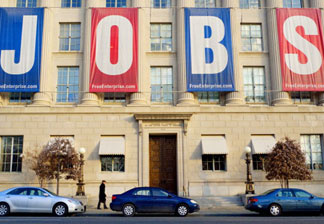 A pedestrian passes under a large banner reading 'JOBS' outside of the Chamber of Commerce January 23, 2011 in Washington, DC. Jobs and job creation are expected to be the centerpiece of US President Barack Obama's State of the Union address on January 25.