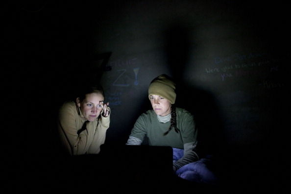 Soldiers working late into the night on their laptop.