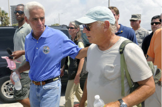 Florida Gov. Charlie Crist (left) and entertainer Jimmy Buffett walk along Pensacola Beach, where Buffett plans to open a new hotel.