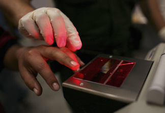 A woman gets her fingerprints taken after she was caught crossing the U.S. border with Mexico illegally, at the U.S. Border Patrol processing center June 21, 2006 in Nogales, Arizona.
