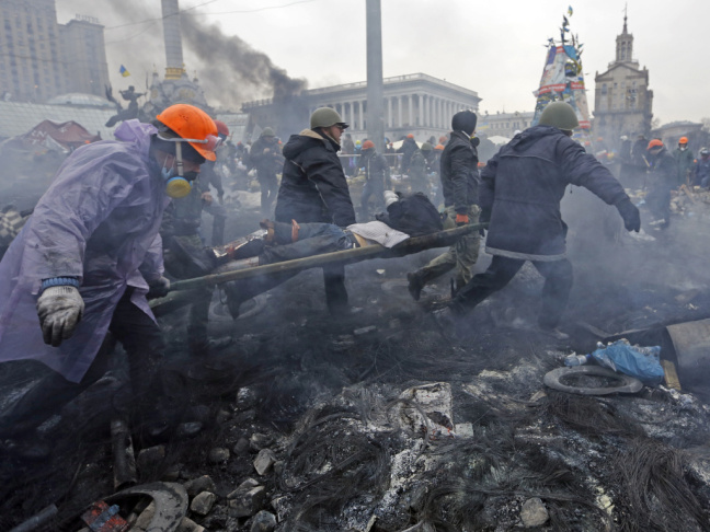 An injured man is carried away Thursday after more clashes between anti-government protesters and police in Kiev.