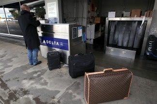 A Delta Air Lines customer checks in curbside in San Francisco. In New York City, international passengers arriving on a Delta flight from London on Monday were accidentally let out of the airport without going through immigration and customs.