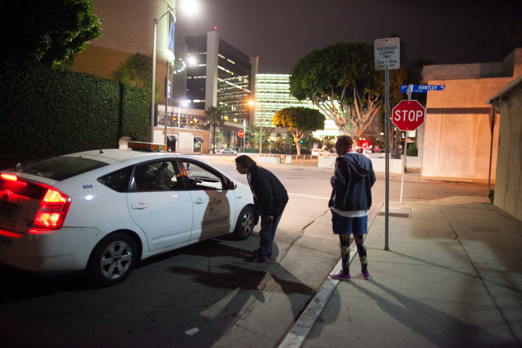 A security patrol stops to offer information on where a group of homeless individuals are sleeping to volunteers Brenda Plantt and Stephan Saengpradap during the homeless census on January 29, 2015.