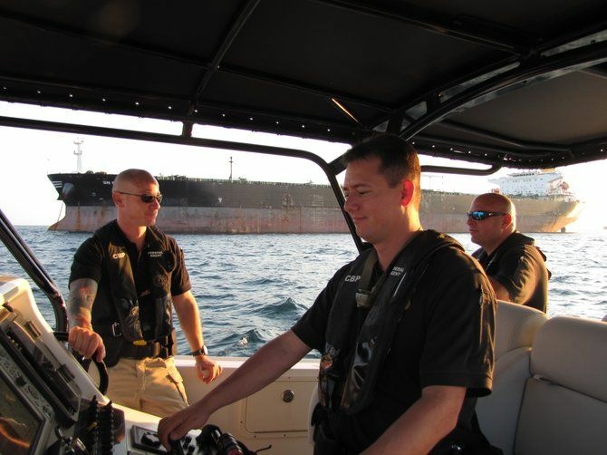 Homeland Security Marine Interdiction Agents on patrol. Behind them is an oil tanker in the Gulf of Mexico. The agents have the authority to inspect any watercraft they deem suspicious.