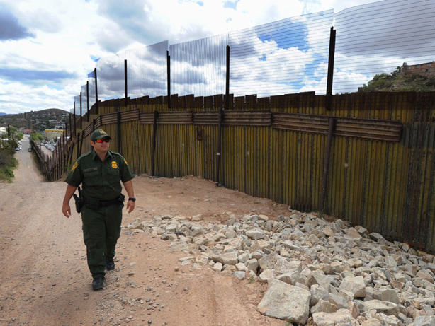 A U.S. Border Patrol officer keeps watch over the fence that divides the U.S. from Mexico in the town of Nogales, Ariz.