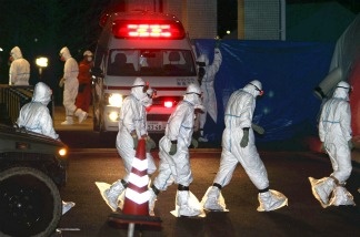 Workers in radiation protection suits prepare for the decontamination of two nuclear plant workers who were exposed to high levels of radiation, upon their arrival at the Fukushima Medical University hospital at Fukushima city on March 24, 2011.