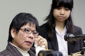 Elmora Cayme, left, reacts during a news conference on Dec. 7, 2010, where she and dozens of hospital workers in California filed suit against their employer, Delano Regional Medical Center, alleging they were the sole ethnic group targeted by an English-only rule. At right is attorney Carmina Ocampo.