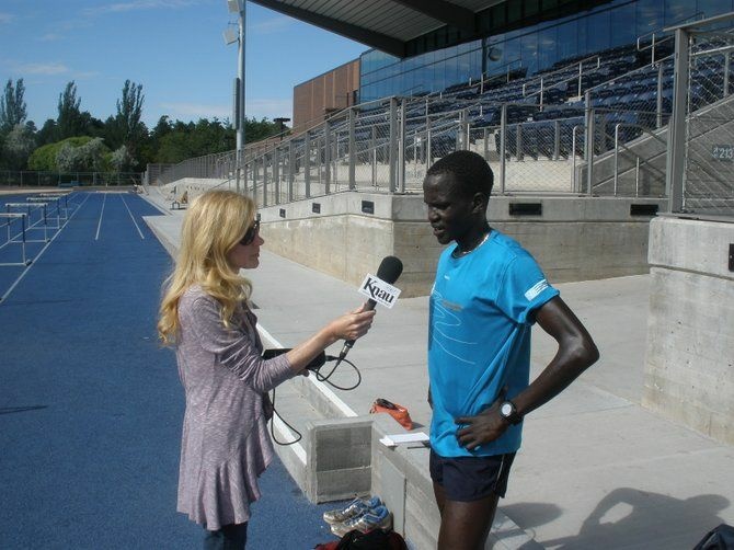 Guor Marial speaks with KNAU'S Janice Baker at the Northern Arizona University track in Flagstaff, Ariz.