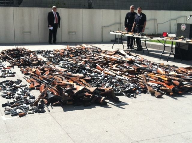 Police Chief Charlie Beck looks at the 1,673 weapons collected during the city's fourth annual gun buyback program.