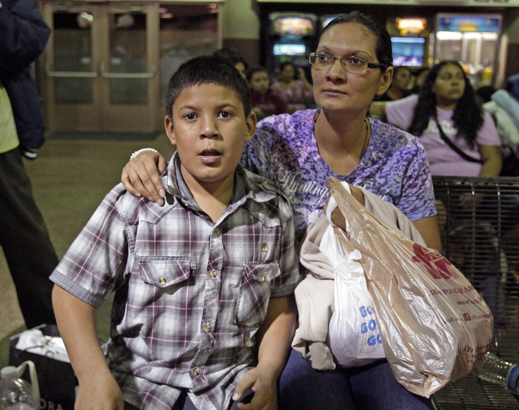 A mother and son in Arizona who've entered the US illegally, sitting at the bus station. Immigration officials say they are dealing with an influx of migrants coming from Central America, many of them unaccompanied minors.