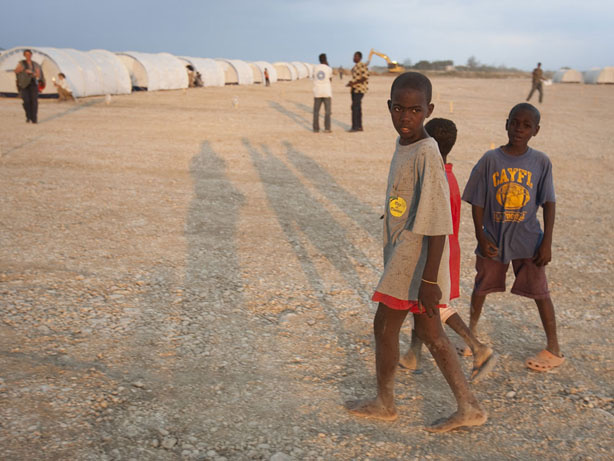 Children relocated from the Petionville Club camp in Port-au-Prince, Haiti, walk through their new home at a government resettlement camp in Corail-Cesselesse. Petionville residents are being moved to the new camp because of the risk of flooding and landslides at the current location during the coming rainy season.