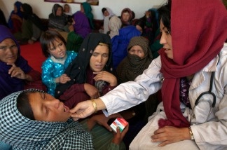 Mid-wife Raqaiu Khoshnod examines a woman at a mobile health clinic June 9, 2011, in the mountain village of Raquol, in Panjab district, Afghanistan.