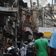 Indian pedestrians walk on a street unde