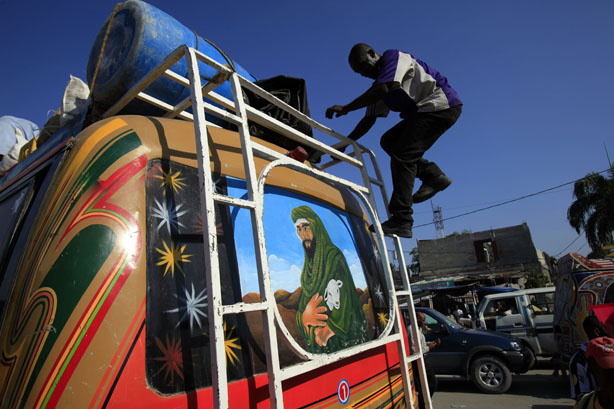 A man walks down a bus that has a painting on its back of Israel's King David in Port-au-Prince, Tuesday, March 30, 2010. The Haitian government will be seeking about $3.8 billion at a United Nations donors conference Wednesday to help the country recover from its Jan. 12 earthquake.