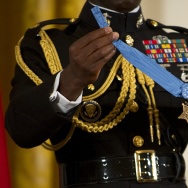 A military aide holds up the Medal of Ho