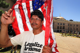 Alberto Gonzalez stands outside the Arizona State capital Building as he joins other protesters to demonstrate against Arizona's tough new immigration laws at a large rally in Phoenix on May 29, 2010.