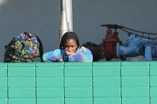 After being released from a school lockdown a student rests her head on a wall outside Gardena High School in Gardena, California January 18, 2011.