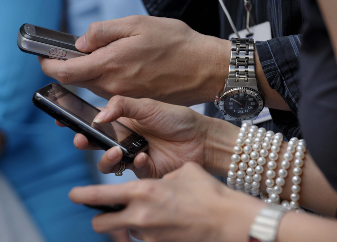Shoppers at a mall send text messages us