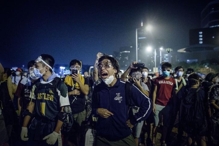 Pro-democracy protesters shout at police forces outside the central government offices in Hong Kong.